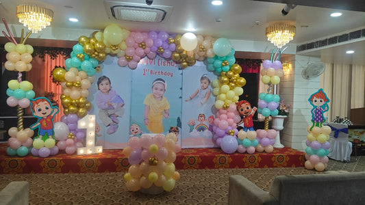 Custom Cocomelon 1st birthday decoration in Jaipur featuring a pastel balloon arch and personalized photo backdrop by Shava Moments.