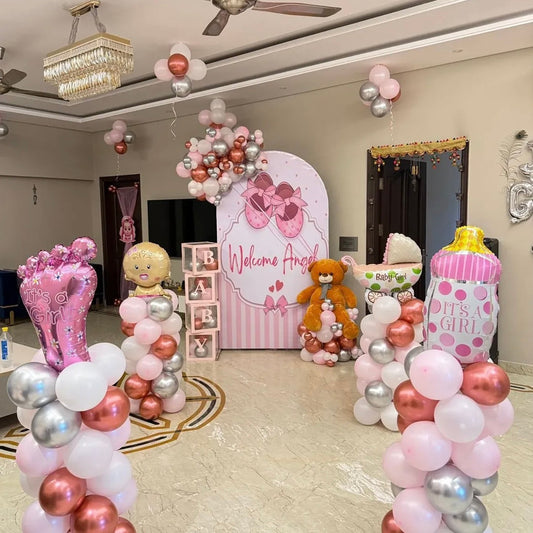 Baby girl welcome decoration in a Jaipur home featuring a pink welcome panel, stacked balloon pillars, baby foils, and a giant teddy bear by Shava Moments.