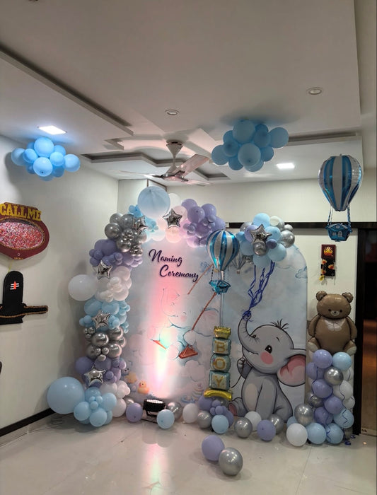 Baby boy naming ceremony setup in Jaipur featuring a hot air balloon and elephant backdrop with blue, purple, and silver balloons by Shava Moments.