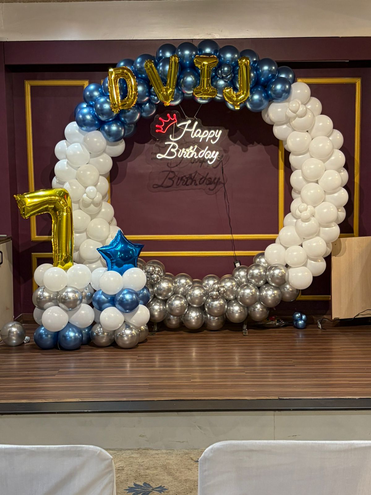 Royal blue and chrome silver circular balloon arch with neon Happy Birthday sign in Jaipur by Shava Moments.
