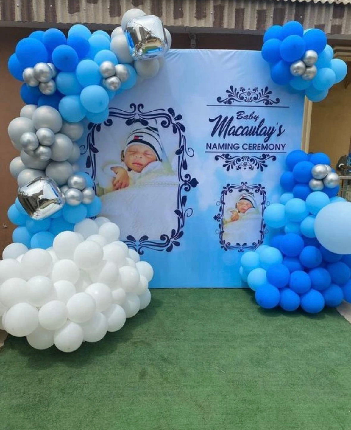 Custom baby boy naming ceremony backdrop in Jaipur featuring blue and silver balloon clouds and personalized photo panels by Shava Moments