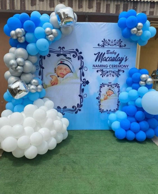 Custom baby boy naming ceremony backdrop in Jaipur featuring blue and silver balloon clouds and personalized photo panels by Shava Moments