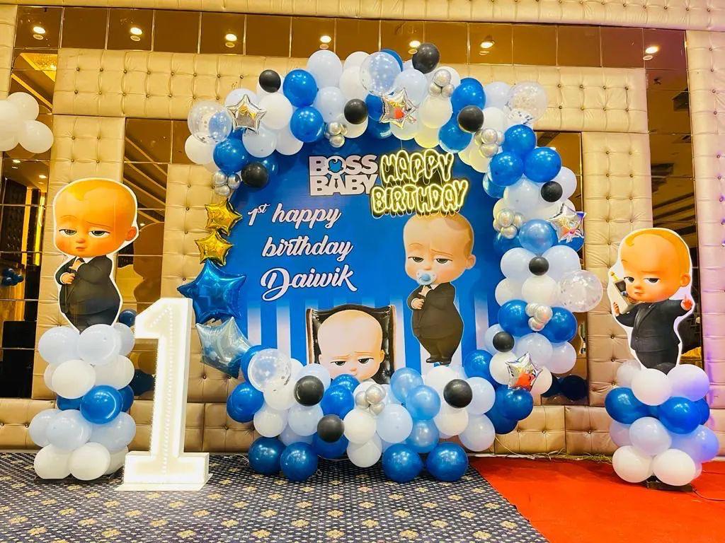 Large-scale Boss Baby themed birthday decoration in a Jaipur banquet hall with blue and white balloon pillars and a grand backdrop.