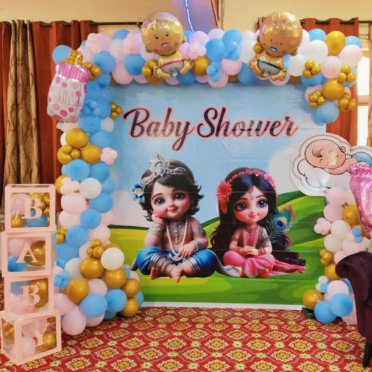 Animated cartoon baby shower backdrop in Jaipur with pink and blue balloon arches, baby block boxes, and a luxury tufted armchair by Shava Moments.